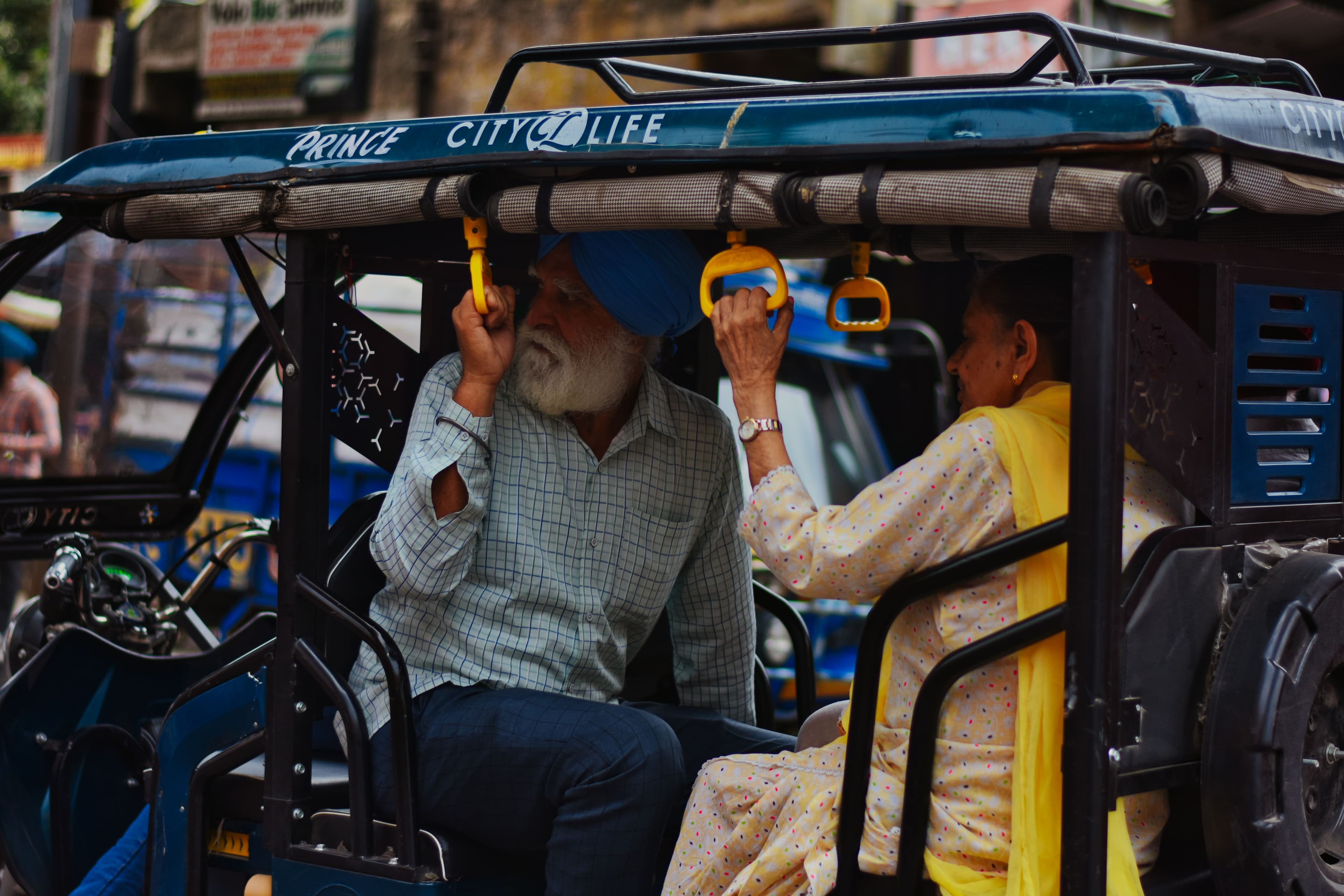 An elderly Sikh couple sharing a warm moment on an auto-rickshaw ride in Amritsar